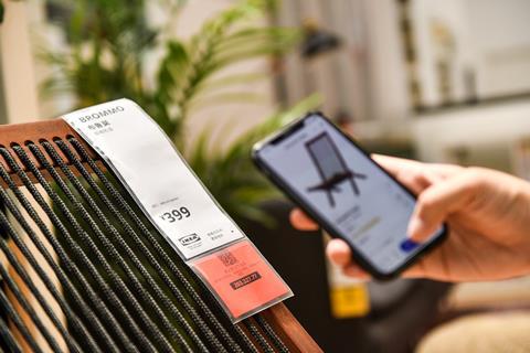 Customer scanning Ikea chair on a smartphone, which gives information on the product
